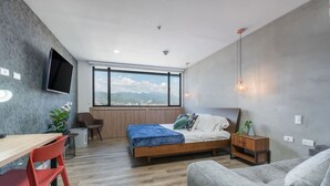 Un dormitorio moderno con una cama grande, un escritorio y un sofá.