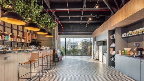 Une cuisine moderne avec des tabourets de bar, un carrelage à motifs et une vue dégagée grâce à de grandes fenêtres.