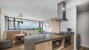 A modern kitchen with a large island, built-in oven, and stainless steel appliances. - Go Living 601 · Amazing Luxury 2BR Apt Poblado - 2AC and coworking (Medellín)