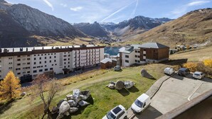 Een hotel met meerdere verdiepingen, een parkeerplaats en uitzicht op bergen en een meer.