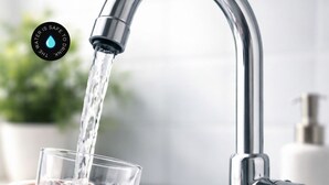 Een moderne kraan met stromend water in een helder glas.