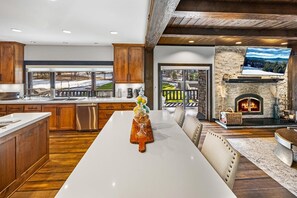 Una cocina moderna con una isla grande, armarios de madera y una chimenea de piedra.