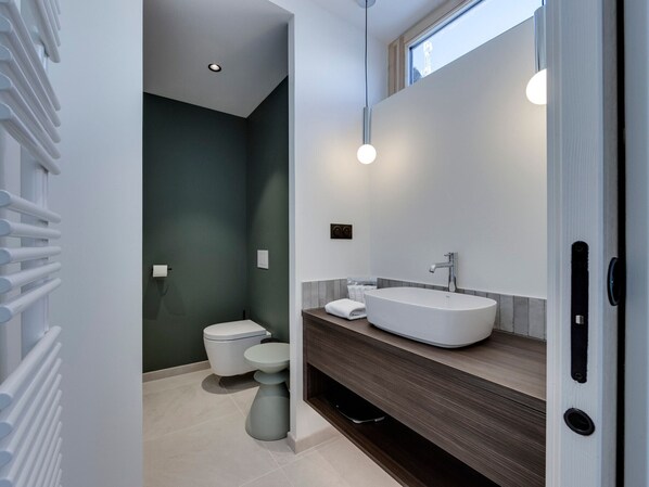 A modern bathroom with a large white sink, a toilet, and a shower area. - Spacious renovated apartment with terrace and parking in Tignes (Tignes)