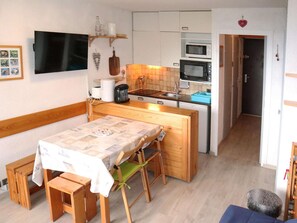 Enjoy meals and snacks in this well-equipped kitchen with a central island, dining table, and basic appliances.