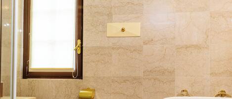 A bathroom with a checkered floor, a toilet, a bidet, and a sink.