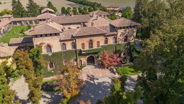 A large, historic building with multiple arched windows and a courtyard.