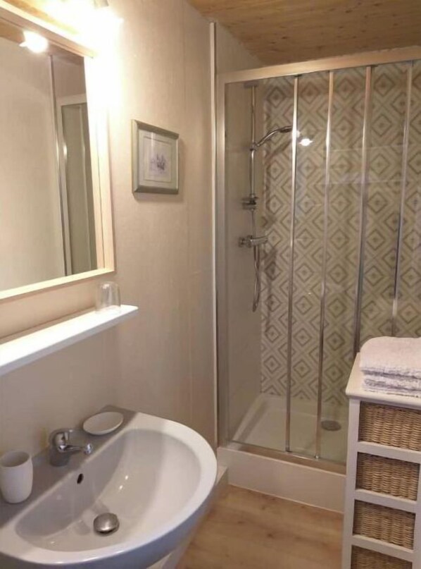 A bathroom with a large mirror, a sink, a shower enclosure, and a towel rack. - La petite enseigne ⭐⭐ Near France's most beautiful km (Champeaux)