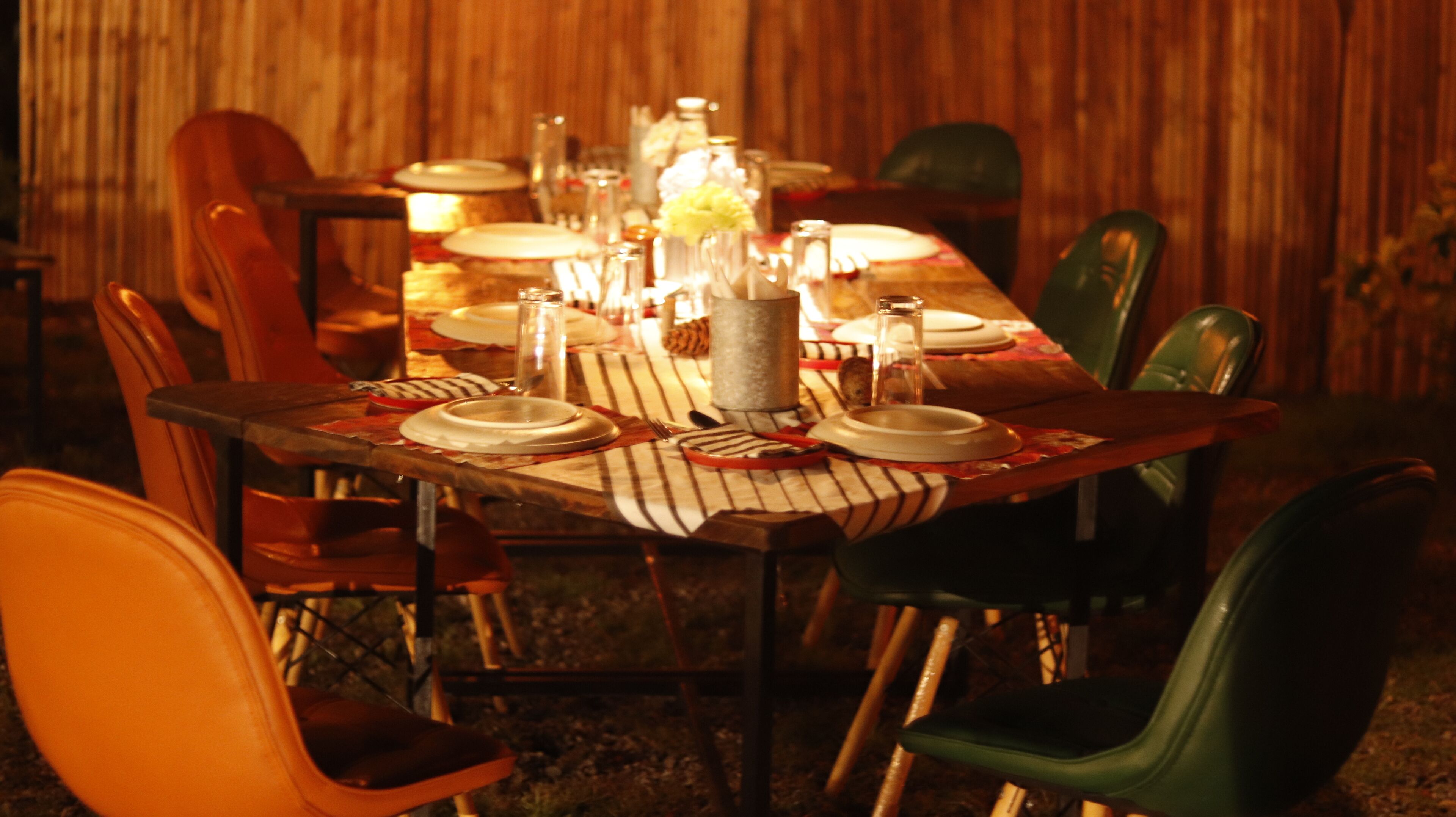 A dining table set with plates, glasses, and a candle centerpiece.