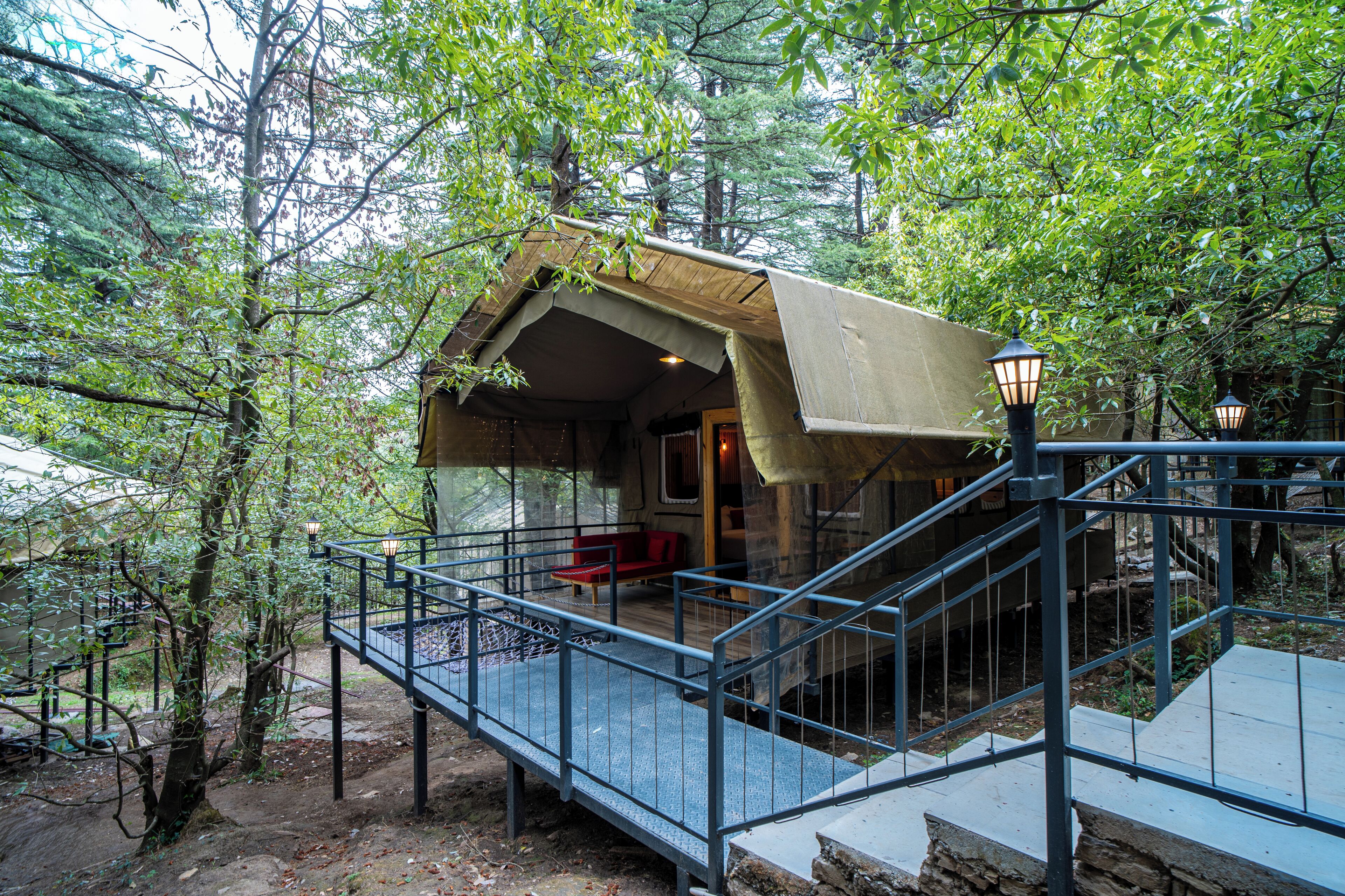 A rustic cabin with a wooden exterior, a covered porch, and a staircase leading to the entrance.