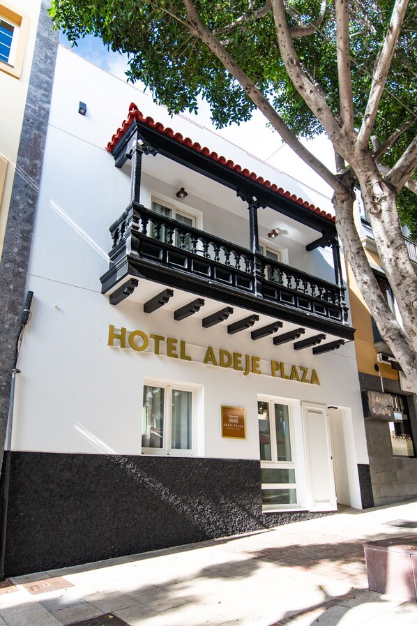 Ein Gebäude mit der Aufschrift 'HOTEL ADEJE PLAZA'.