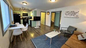Un espace de vie compact comprenant une cuisine, un coin repas et un salon.