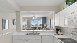 Una cocina moderna con armarios blancos, estufa integrada y vistas al patio exterior.