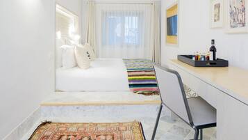 Un dormitorio pequeño con cama, escritorio y silla.