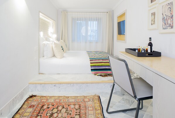 Un dormitorio pequeño con cama, escritorio y silla.