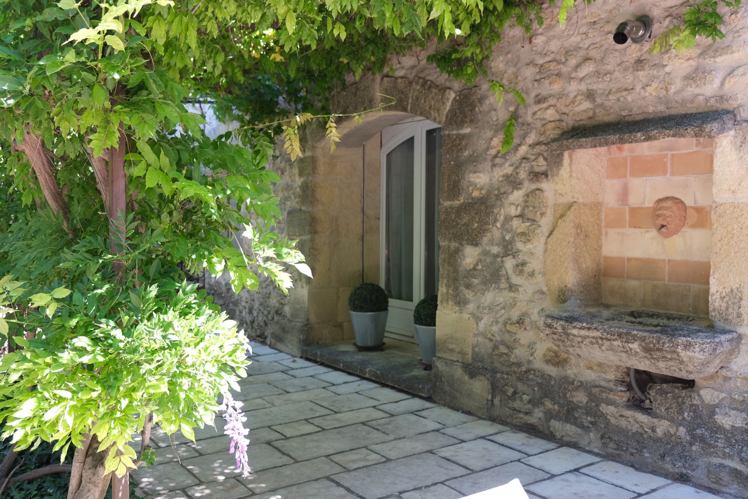 A stone wall with a small window and a stone bench.