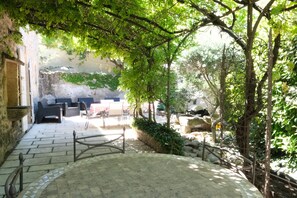 A courtyard with stone flooring, outdoor furniture, and a pergola providing shade. - Vacation rental with pool CHEVAL BLANC LS2-413 (Cheval Blanc)