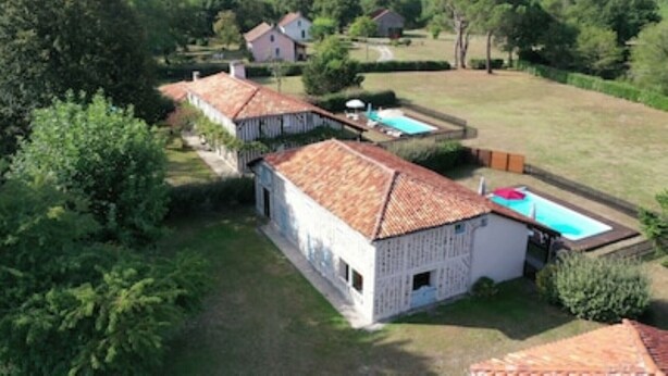 Una propiedad residencial con piscina, una casa independiente y jardín.