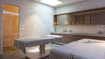 Relax in a serene space with a large mirror, two massage tables, and a comfortable vanity area.