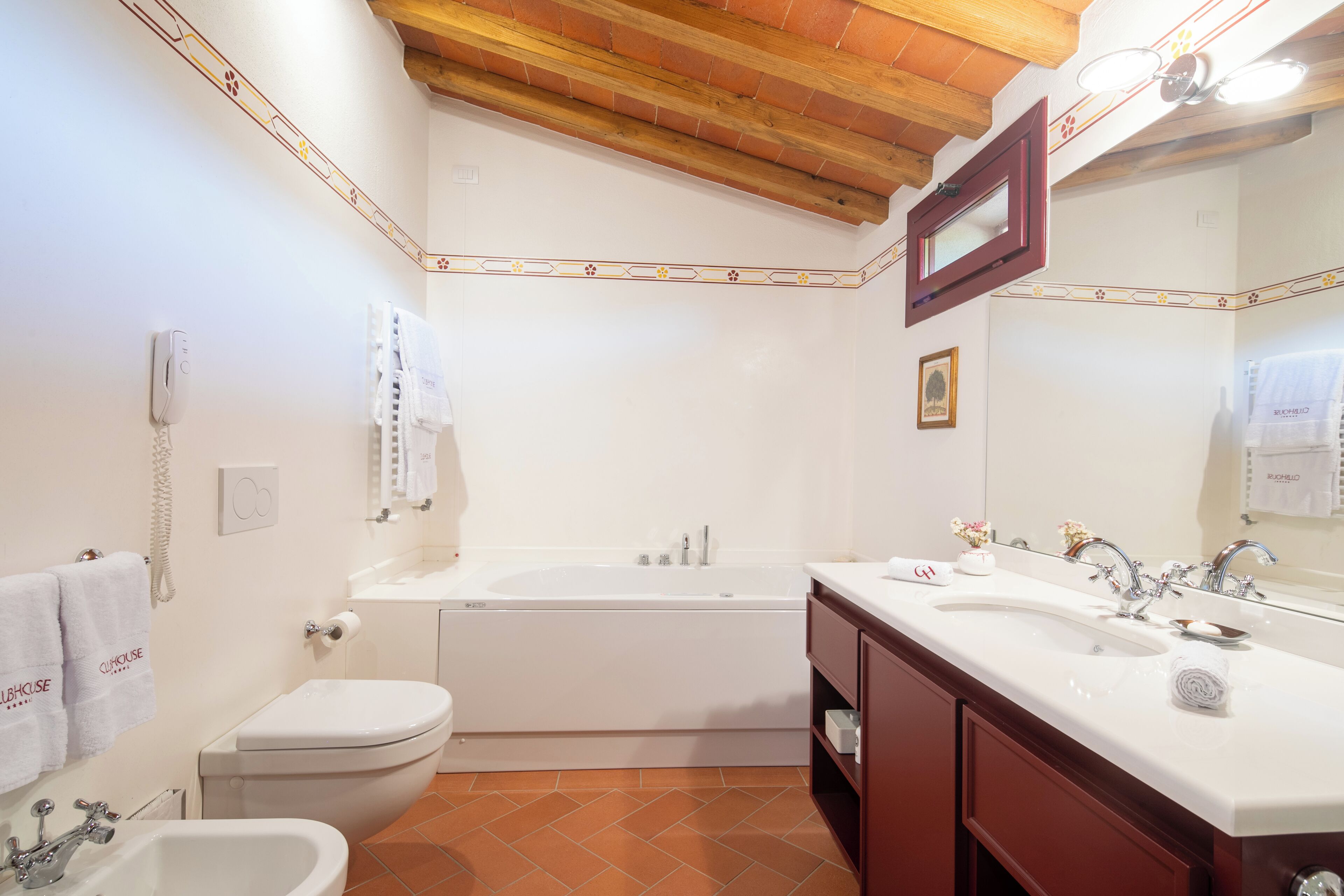 Une salle de bain avec une baignoire, des toilettes, un lavabo et un meuble-lavabo.