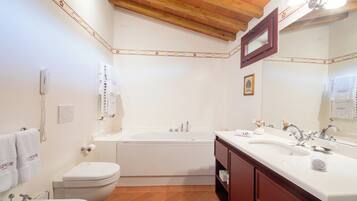 Une salle de bain avec une baignoire, des toilettes, un lavabo et un meuble-lavabo.
