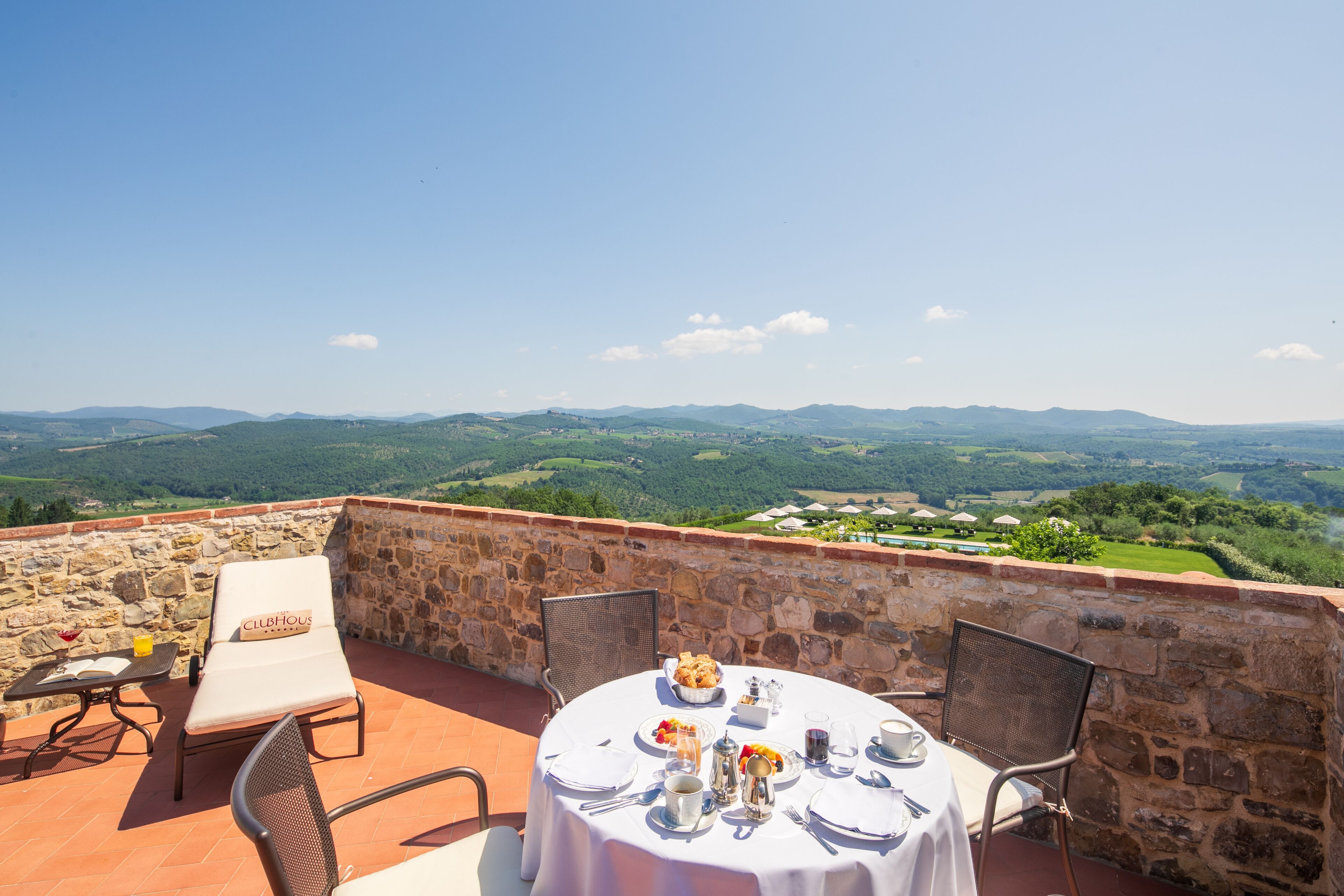 Une terrasse avec une table dressée pour le dîner, offrant une vue sur un paysage magnifique.