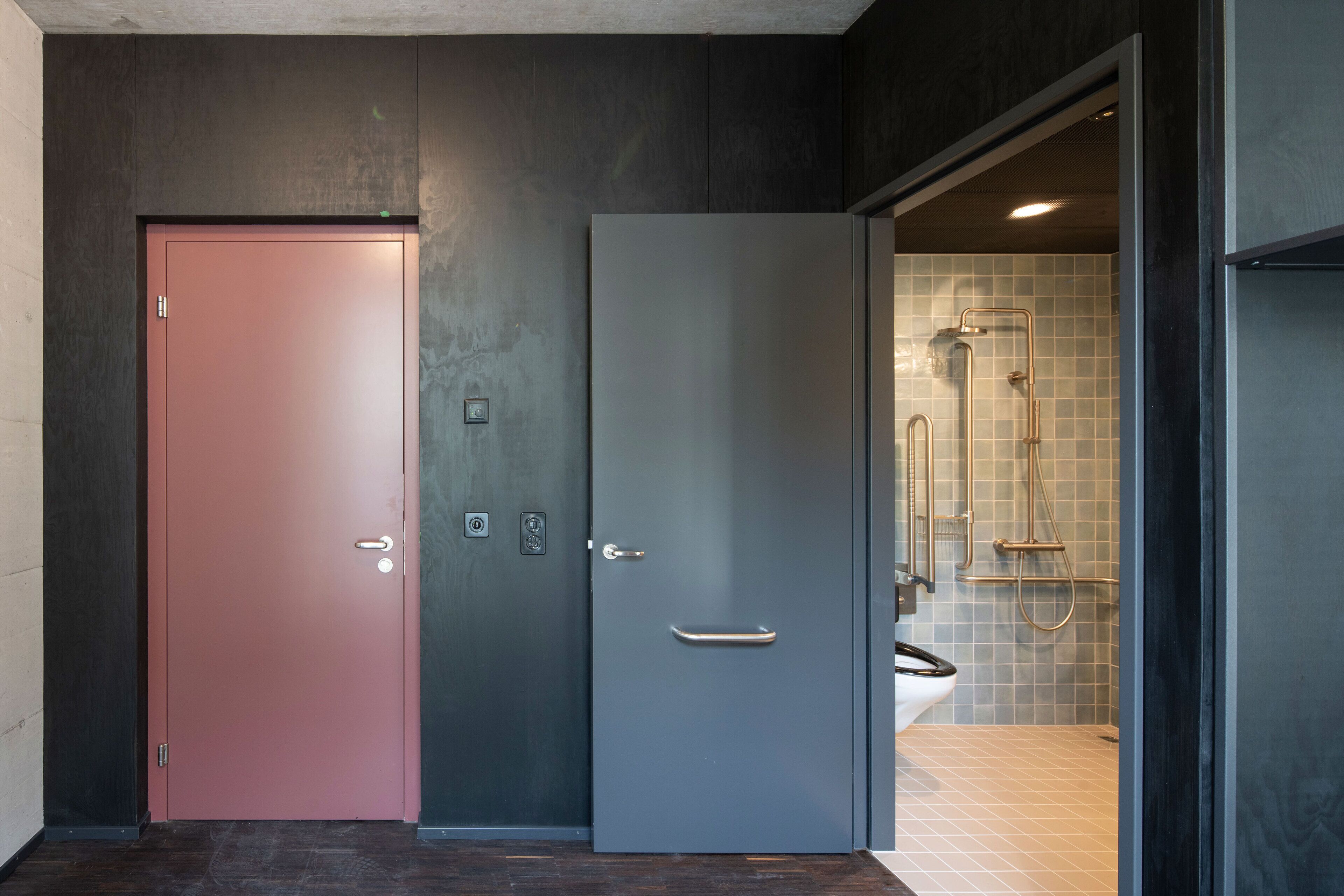 A modern bathroom with a shower, toilet, and sink.