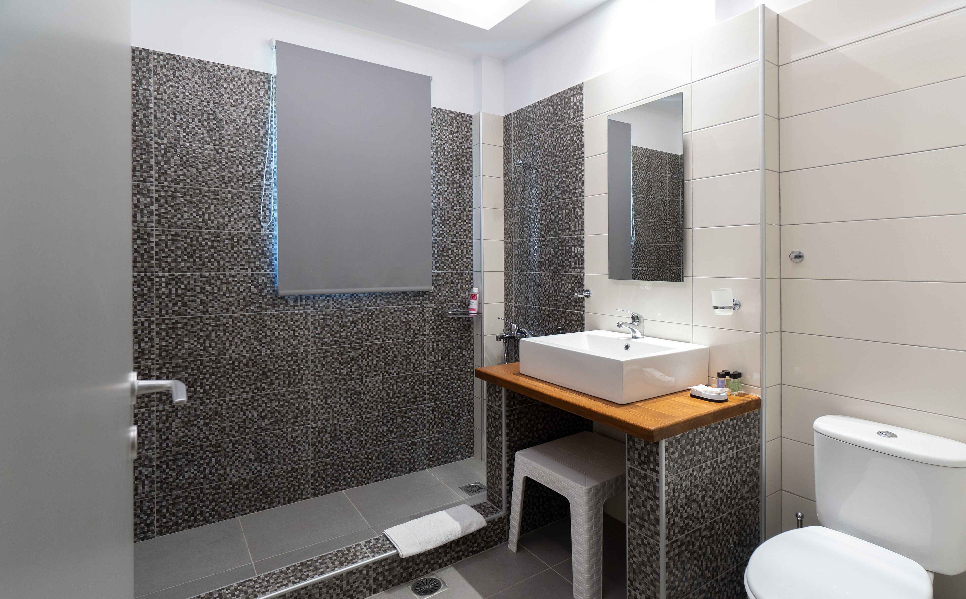Un baño moderno con ducha, lavamanos e inodoro.