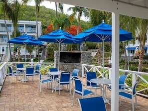 Relax in style with comfortable seating and a cozy fireplace, surrounded by lush greenery and a scenic view.