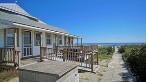 Ein Küstenhaus mit einer Holzterrasse und Blick aufs Meer.