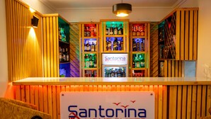 A bar area with wooden paneling and a sign for Santorina Home Suites. - Santorina Home Suites (Kisii)