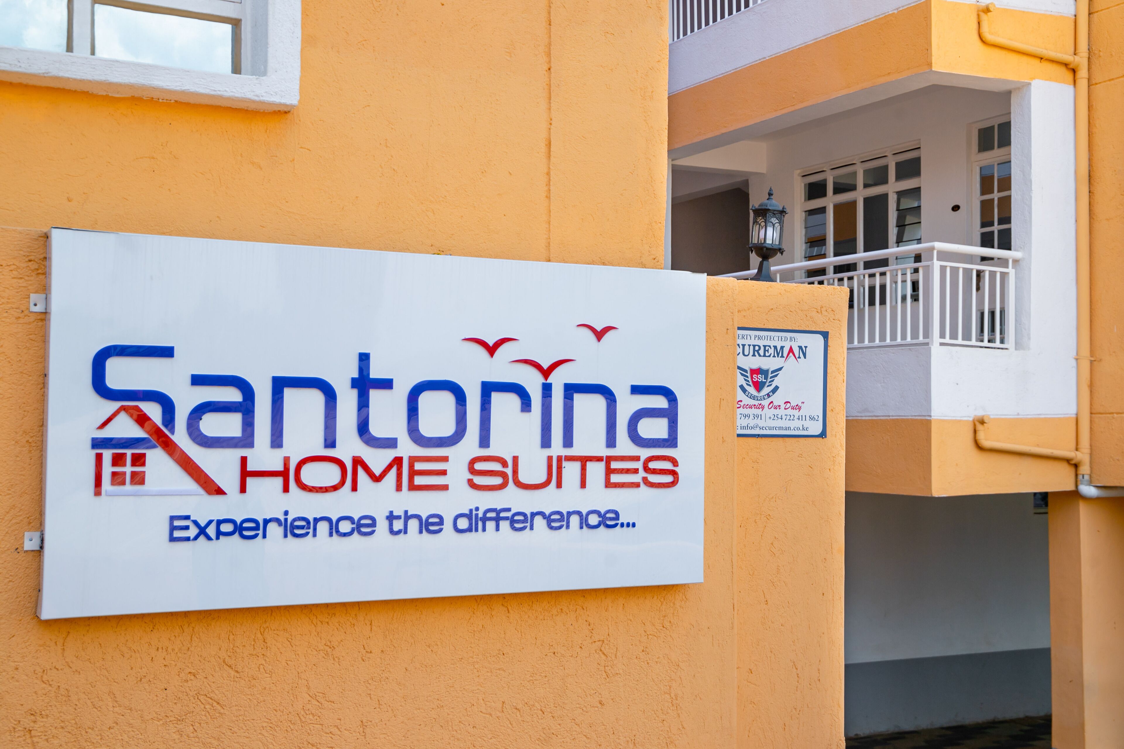 Letrero de Santorina Home Suites que anuncia una experiencia como en casa.