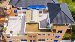 A multi-story building with a flat roof, multiple windows, and a central courtyard. - Santorina Home Suites (Kisii)