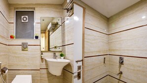 A bathroom with a toilet, sink, and shower.