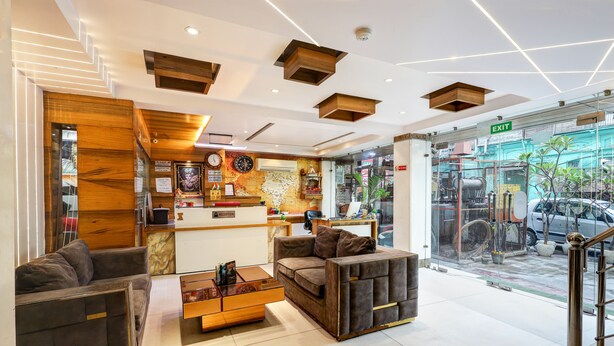 A modern lobby with a reception desk, seating area, and a view of the street outside.