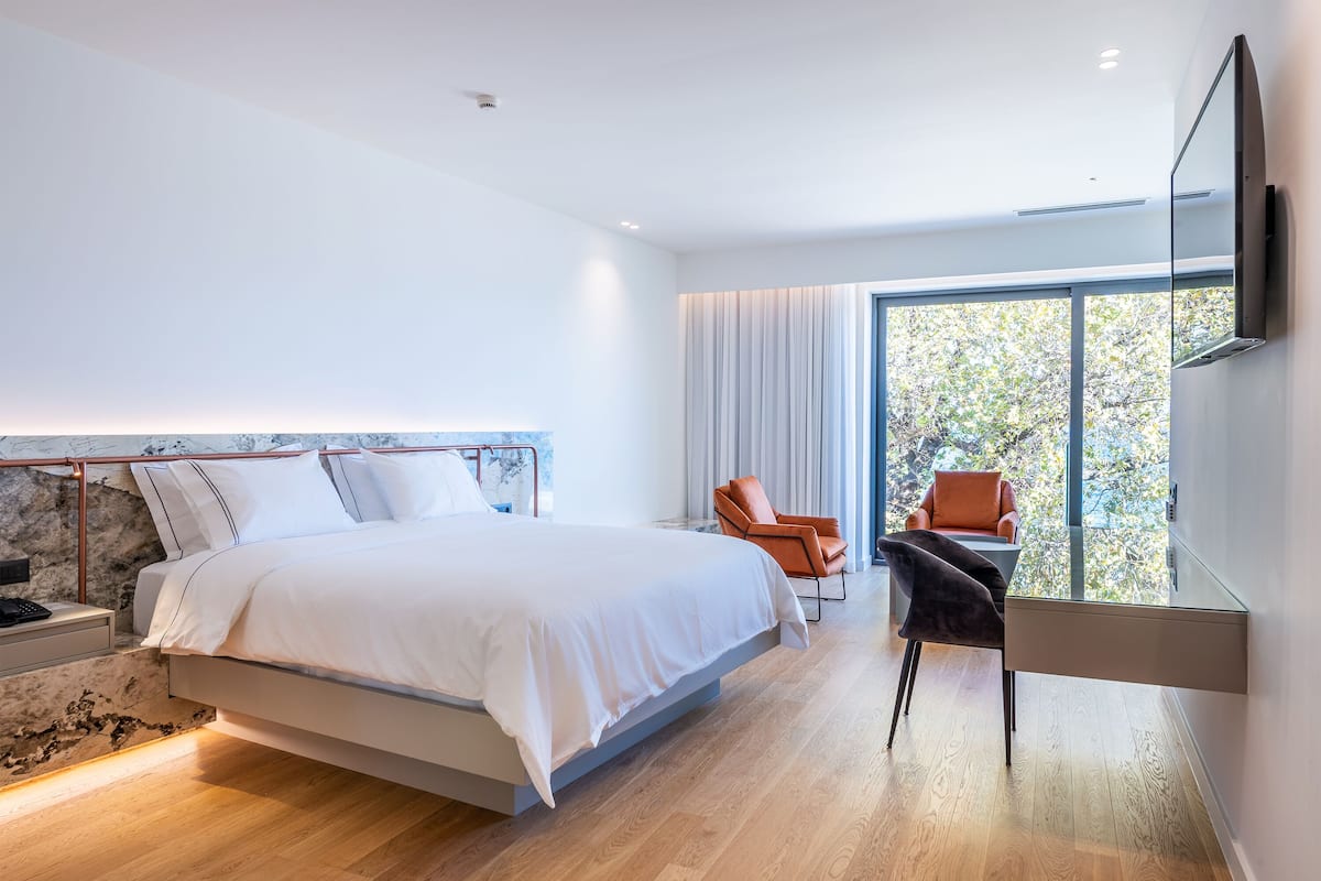 Un dormitorio moderno con una cama grande, un escritorio y una silla.