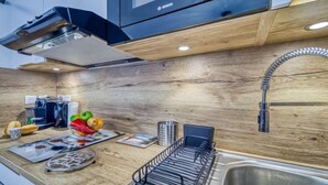 Een moderne keuken met houten kastjes, een roestvrijstalen spoelbak en een ingebouwde oven.
