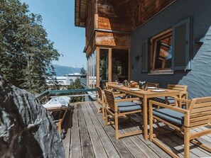 A wooden deck with a table and chairs, overlooking a mountainous landscape. - Chalet 1018 by Interhome (Bad Gastein)