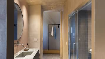 Un baño moderno con un espejo grande, lavamanos dobles y cabina de ducha de vidrio.