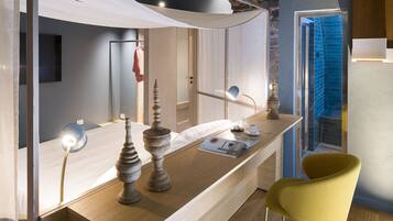 Une salle de bain moderne avec un meuble-lavabo en bois, une chaise jaune et un espace de douche carrelé de bleu.
