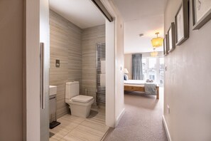 En-suite bathroom with heated towel rail, toilet and view to bedroom, large pet-friendly holiday home in Rhosneigr, Anglesey - Out of the Blue: Spacious pet-friendly holiday home in Rhosneigr (Rhosneigr)