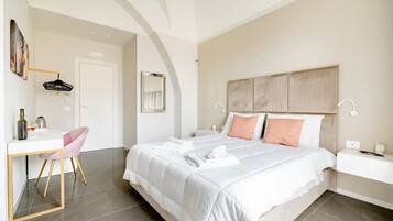Een slaapkamer met een bed, nachtkastje, stoel, bureau en een deur.