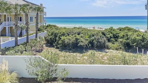 A coastal view with a building, beach, and clear sky. - "Surfer Dog" | Beachfront Pool | Includes Beach Chairs & Bikes (Inlet Beach)