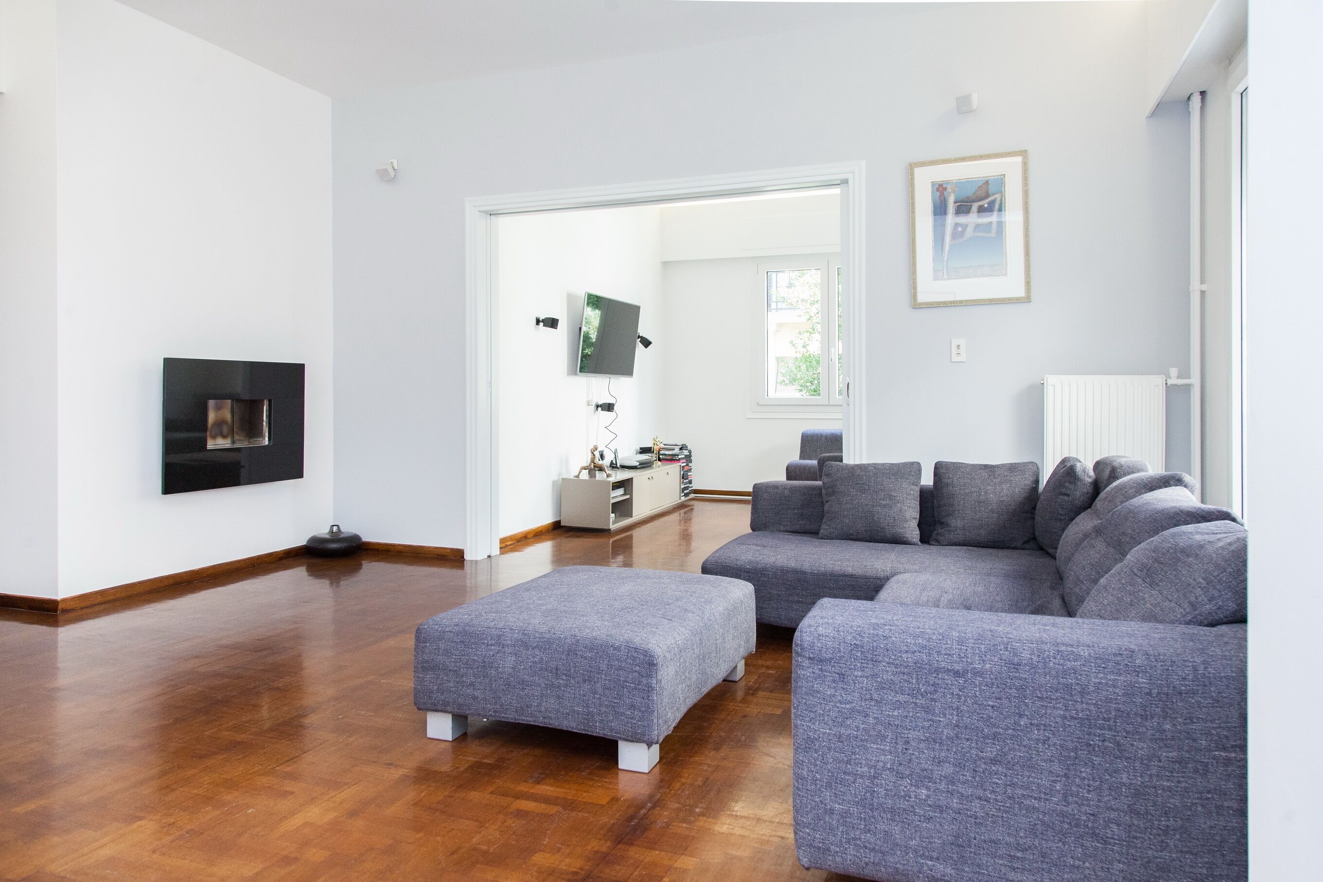 A modern living room with a sectional sofa, a flat-screen TV, and a fireplace.