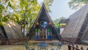 Edificio de techo triangular con un patio que incluye una mesa y sillas.
