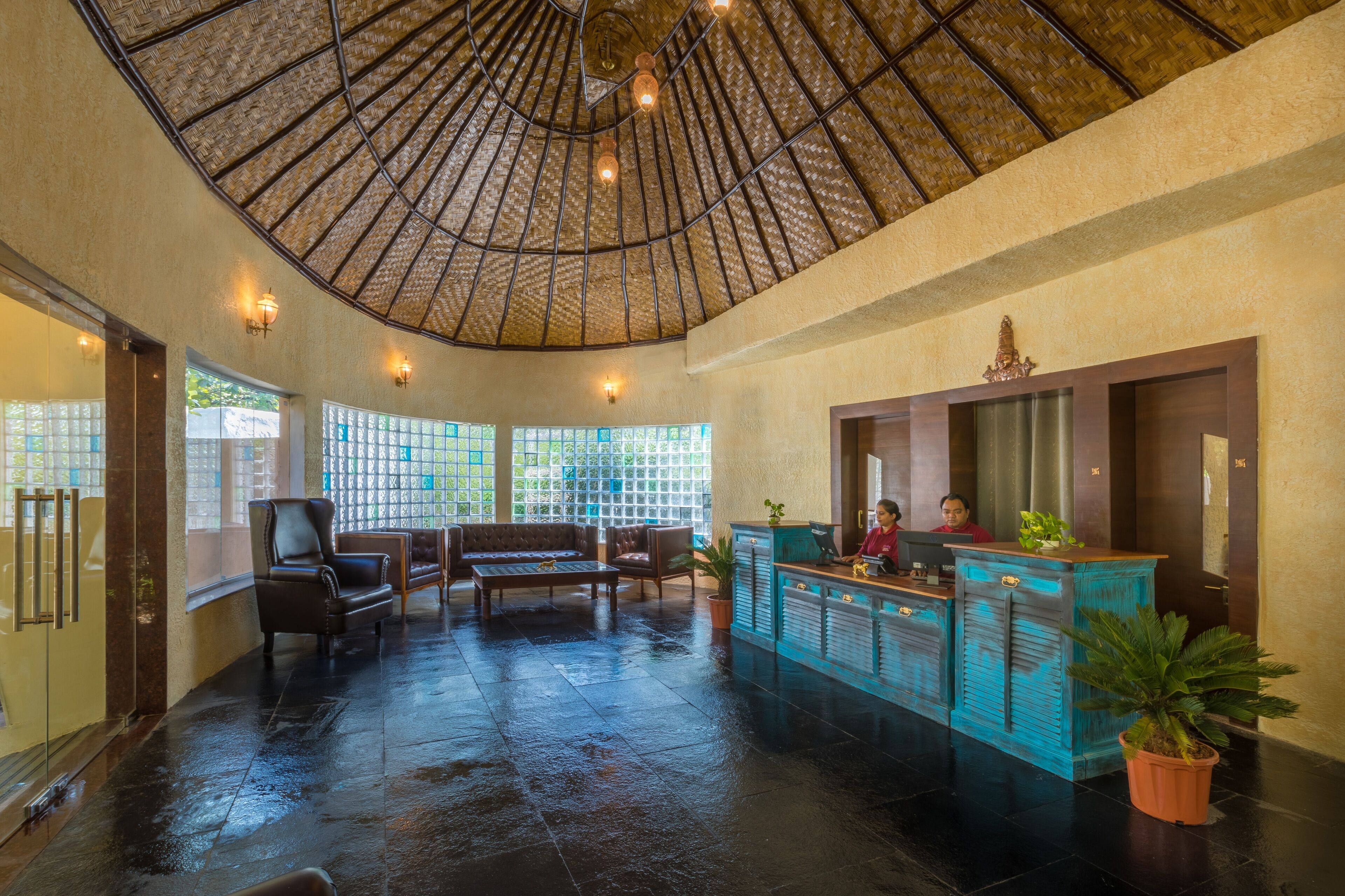 A spacious lobby with a high ceiling, a reception desk, seating area, and large windows.