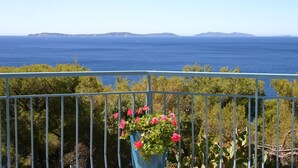 Un balcon avec vue sur la mer et sur la terre, au loin.