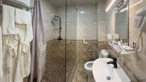 Ein modernes Badezimmer mit einer Duschkabine, einer Toilette und einem Waschbecken.