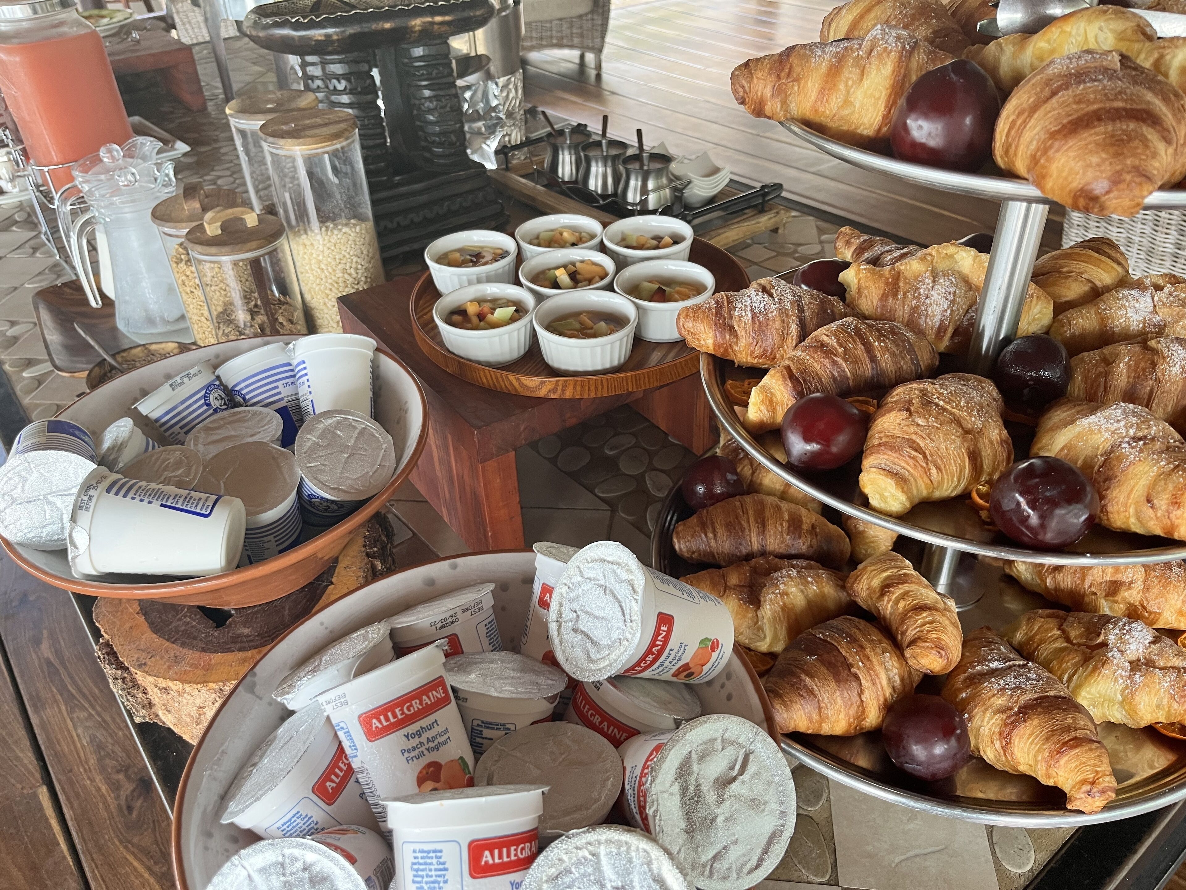 A breakfast buffet with pastries, fruits, and dairy products.