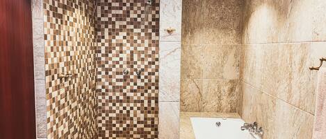 A bathroom with a checkered shower wall, a bathtub, and a marble floor.