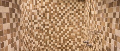 A shower with a checkered tile pattern and a showerhead.